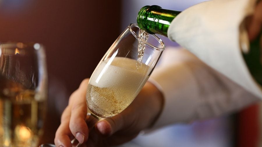 Bartender pouring Champagne into glass, close-up